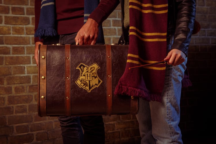 Fans carrying magical luggage and wearing house scarves